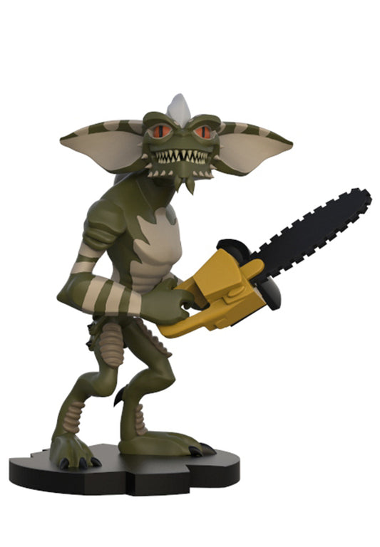 Gremlins The Movie collectible figure of a green creature holding a yellow and black chainsaw, standing on a black base against a white background.
