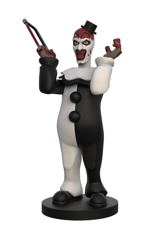 A stylized horror clown figurine standing on a round black base, wearing a black-and-white suit, red face paint, and holding a chainsaw in one hand, photographed on a plain white background.