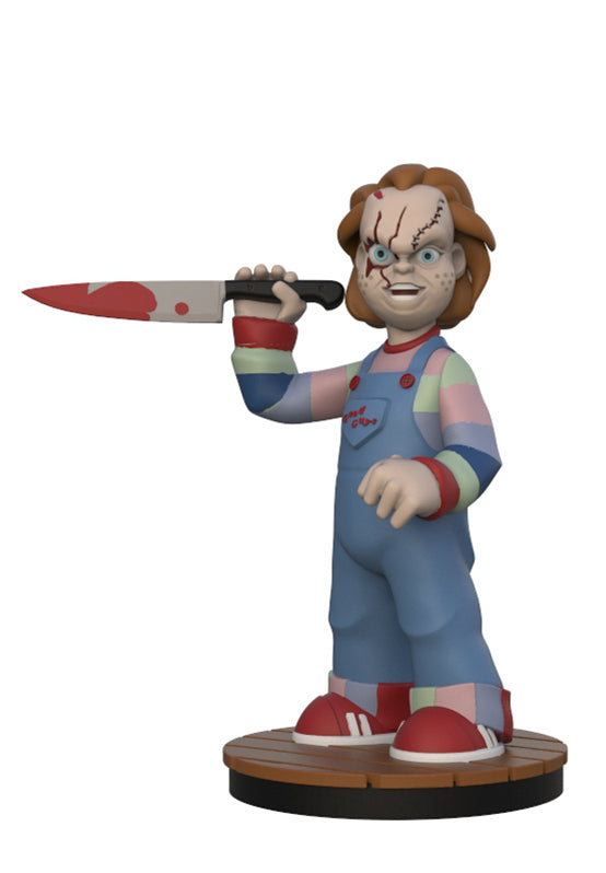 A collectible vinyl figure of Chucky holding a bloody knife, standing on a round wooden base against a plain white background.