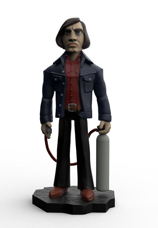 A stylized 3D figurine of a man with dark hair and glasses, wearing a dark blue jacket over a red shirt, black pants, and brown shoes, holding a gray cylinder connected by a red hose, standing on a black base against a white background.