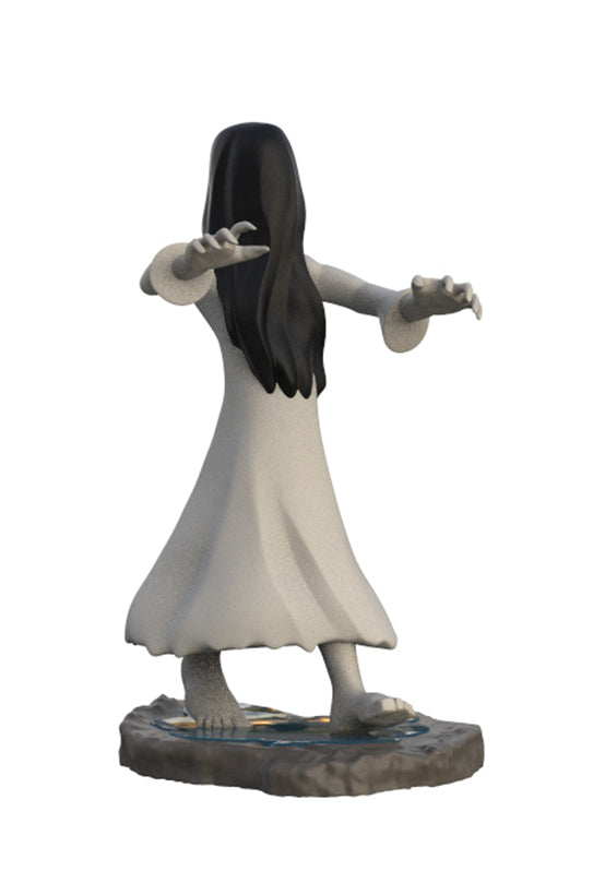 A miniature figurine of a ghostly woman with long black hair and a flowing white dress, standing on a rocky base against a plain white background.