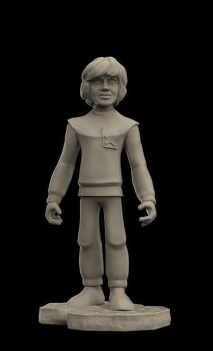 A light gray 3D-printed figurine of a young boy with short hair, wearing a tunic and pants, standing on a round base against a solid black background.